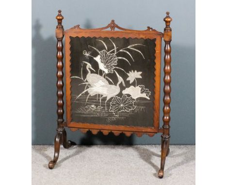 A Victorian walnut framed fire screen inset with embroidered panel depicting exotic birds amongst the rushes, with shaped and