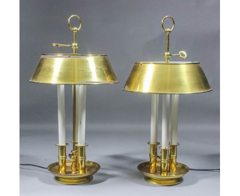 A pair of brass electric table lamps, each in the form of triple candlestick on circular bases and with brass shades for same