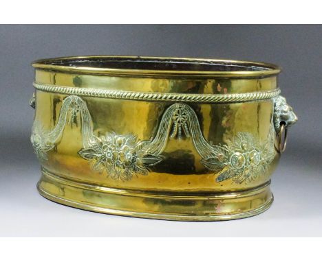 A late 19th/early 20th Century Dutch brass oval two-handled jardiniere, the sides with repousse decoration of flowering swags
