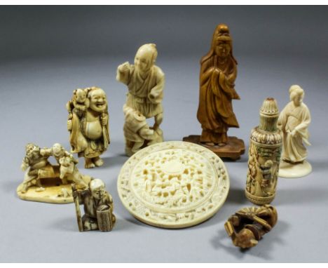 A Japanese ivory netsuke of Hotei carrying a child on his shoulders, 3ins (7.6cm) high, signed, together with seven other pie