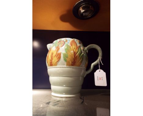 A Clarice Cliff turquoise ground jog of ovoid ribbed form moulded in relief with berries and autumn leaves 