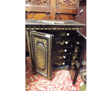 A mid-20thC Chinese chinoiserie decorated cabinet the panelled doors depicting scenic views with sages and flowers, enclosing