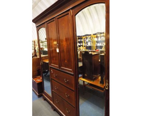 A good quality Edwardian mahogany boxwood and chequer strung compactum wardrobe, the moulded cornice above a pair of ornately