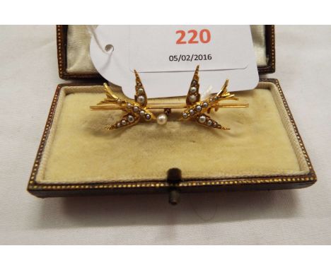 A yellow metal bar brooch in the form of two swallows, set with seed pearls and with central pearl drop, boxed  No markings a
