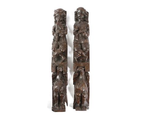 A PAIR OF OAK FIGURAL TERMS17TH CENTURYeach carved as a figure, one with a book, the other playing the bagpipes, each above a