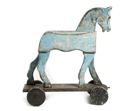 A FOLK ART PAINTED PULL-ALONG TOY HORSEon a four wheel base50cm high, 47cm long, 18.5cm wideProvenanceThe Howard Collection o