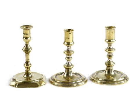 A PAIR OF QUEEN ANNE BRASS TAPERSTICKSEARLY 18TH CENTURYeach with a cylindrical nozzle above a knopped stem and banded, sprea