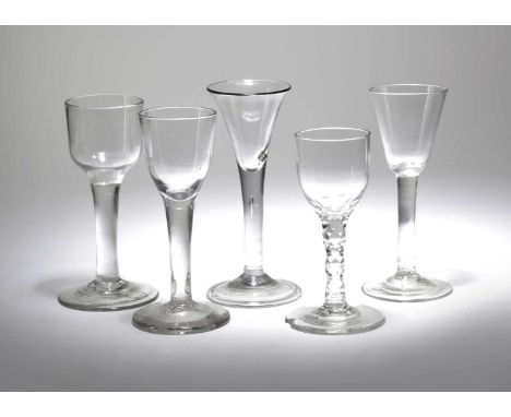 FIVE DRINKING GLASSES18TH CENTURYcomprising: one with a trumpet bowl and teardrop stem, one with an ogee bowl and plain stem,