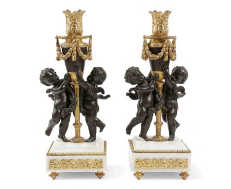 A PAIR OF FRENCH GILT AND PATINATED BRONZE CANDELABRA BASESIN LOUIS XVI STYLE, LATE 19TH / EARLY 20TH CENTURYeach modelled wi