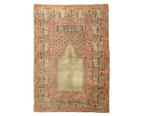 A GHIORDES PRAYER RUGWEST ANATOLIA, C.1880the pale mint green field with hanging lantern beneath a steep Mihrab framed by upp