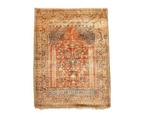 A HAJI JALILI TABRIZ SILK PRAYER RUGNORTH WEST PERSIA, C.1890the deep madder field with an urn issuing flowers beneath a hang