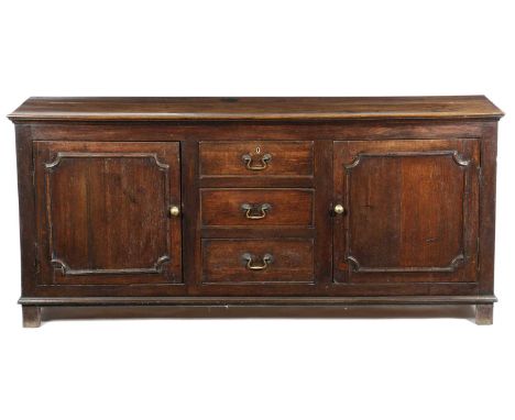 A GEORGE III OAK LOW DRESSERSECOND HALF 18TH CENTURYwith a pair of cupboards with outlne mouldings enclosing a shelf, flankin