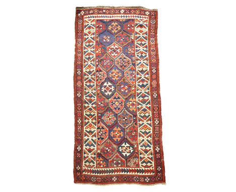 A BAKHTIARI RUNNER WEST PERSIA, C.1925the polychrome serrated honeycomb lattice field of cruciform guls enclosed by ivory bor