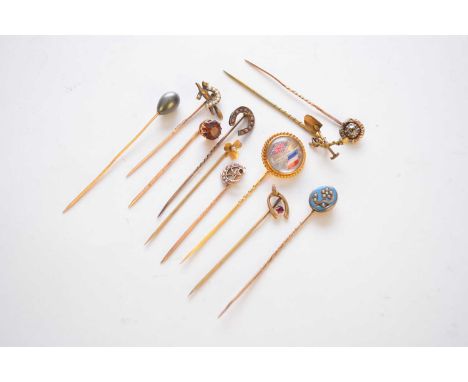 A collection of eleven stick pins, comprising; a reverse carved intaglio example depicting the Union Jack and Tricolour, a si