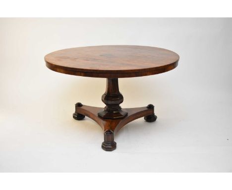 An early Victorian rosewood veneered breakfast table, the circular, tilt-top above an octagonal baluster support, raised on a