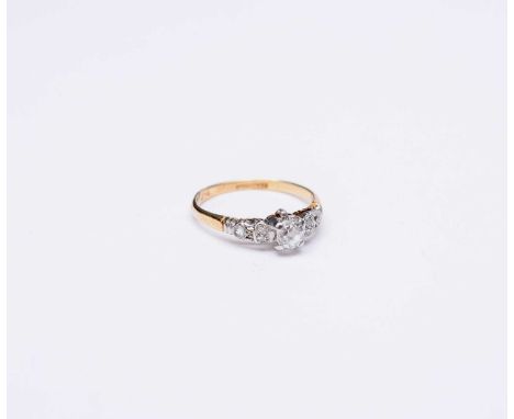 An old mine cut diamond ring, claw set in white metal with rose cut diamond set shoulders, the yellow metal shank stamped '18