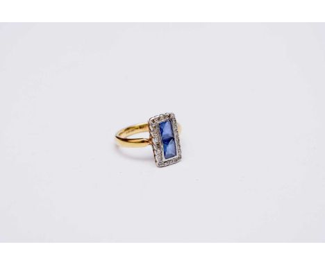 A sapphire and diamond elongated rectangular cluster ring, the yellow metal shank stamped '750', ring size J, weight approx 4