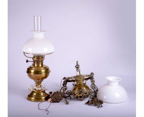 A brass hanging oil lamp, late Victorian, the reservoir suspected between three scroll arms with chains to a gothic influence