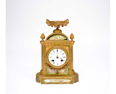 A French gilt-metal mantel clock, of architectural form with urn finial, inset with Sevres style porcelain panels, the 3in (7