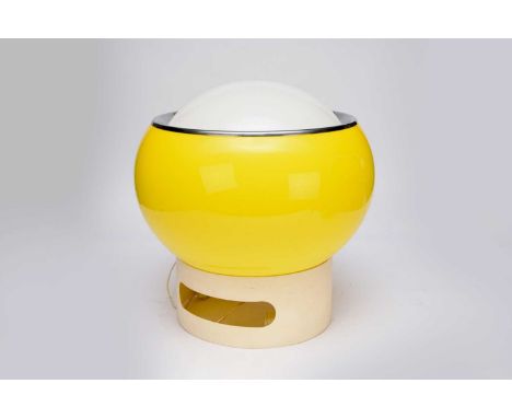 A mid-century Polish acrylic table lamp, formed as a bright yellow and opaque white acrylic globe with chromium band, resting