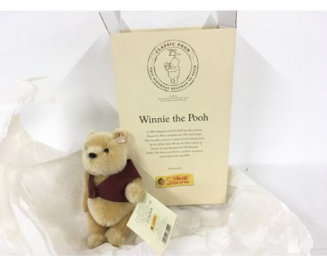 A boxed 75th anniversary edition of Winnie the Pooh by STEIFF. Button in ear.