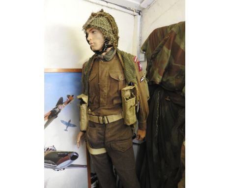 A standing mannequin wearing Parachute Regiment field uniform with webbing, Bergen backpack and a camouflage helmet 