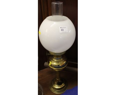 20th century brass double burner oil lamp with brass reservoir, reeded column and domed base. White shade and clear chimney. 