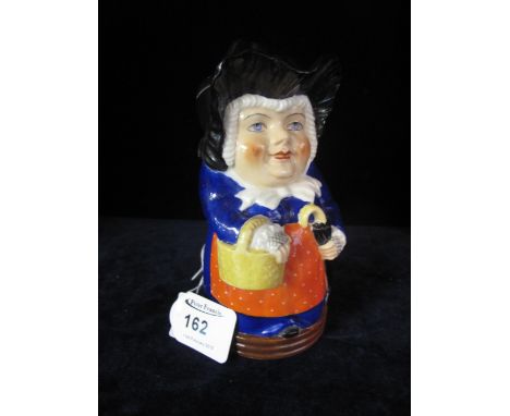 Royal Worcester Toby jug in the form of a woman with umbrella and basket, printed puce marks to base. 