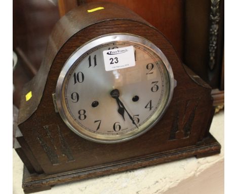 Mid 20th century oak dome topped two train mantle clock with silvered face. 