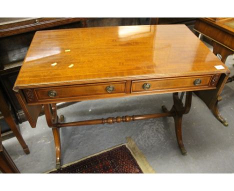 Reproduction mahogany inlaid two drawer sofa table on brass claw feet and casters. 