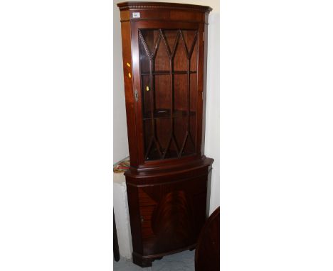 Reproduction mahogany astragal glazed corner cabinet on bracket feet. 