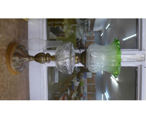 An early 20th Century oil lamp with cut glass reservoir and spare chimney