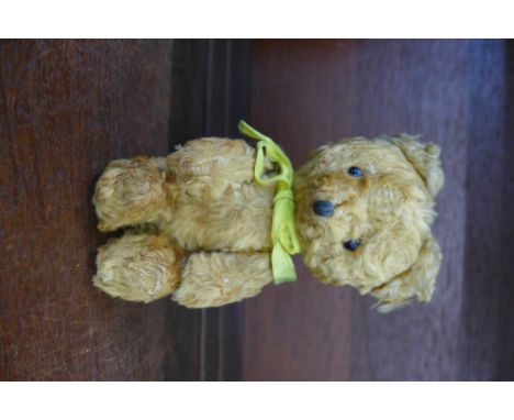 A small Teddy bear with jointed limbs and button eyes