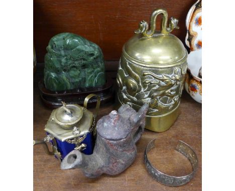 A Chinese brass bell, a stone carving, two teapots and a bangle