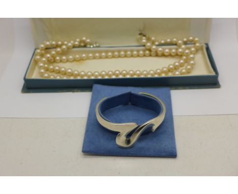 A silver bangle with box and a triple string of faux pearls