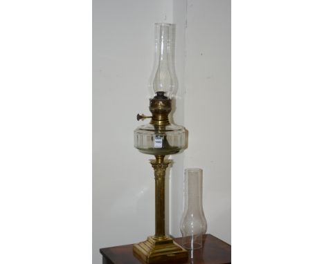 A vintage brass Corinthian style oil lamp, with glass funnel above glass reservoir, spare glass funnel, 52cm high