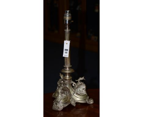 A Victorian plated candlestick converted to table lamp, decorated with three winged dragon terminals to the base, terminating