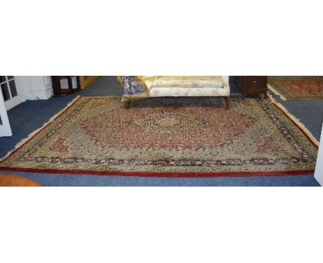 A Tabriz carpet, with foliate medallion to the centre, on red and blue ground, with foliate border, 396 x 270cm