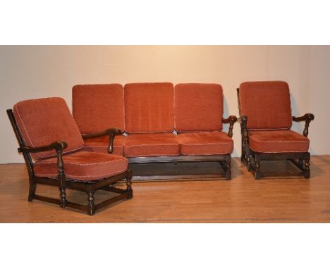 An Ercol sofa and twin armchair suite, with red loose cushion seats and backs, sofa 170cm wide x 92cm deep (3)