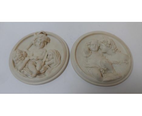 Pair of early/mid 20thC circular plain ceramic cast wall plaques depicting young children & are indistinctly inscribed on the