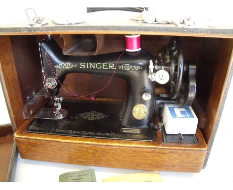 Cased vintage Singer sewing machine with various instruction manuals, accessories etc, in crocodile skin effect case 