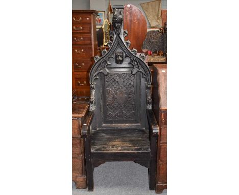 A Gothic revival carved oak throne chairThe back rest is a marriage to the seat and arms, some minor losses to the extremitie