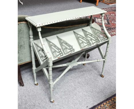 A reproduction Regency style painted two-tier book trough with gadrooned top, open fret dividers and side panels, with ring t