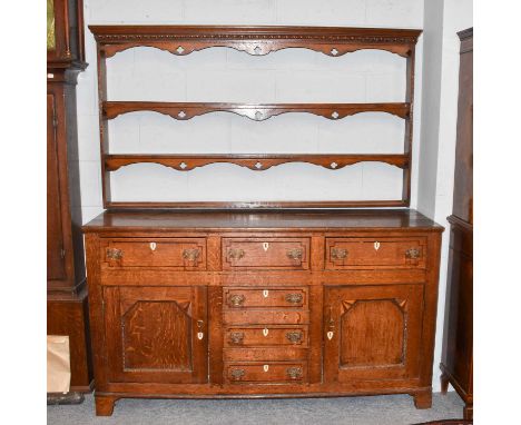 A George III oak dresser banded in rosewood with bone shield shaped escutcheons and bobbin turned mouldings, 157cm by 46cm by