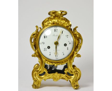 An ormolu striking mantel clock, case with scroll decoration, side sound frets, carrying handle, 4-1/4-inch enamel dial beari