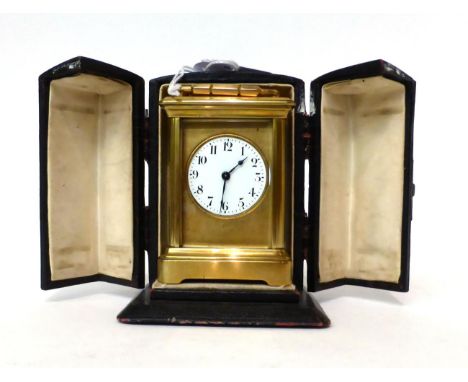 * A small brass carriage timepiece, circa 1900, carrying handle, enamel dial with Arabic numerals, single barrel movement wit