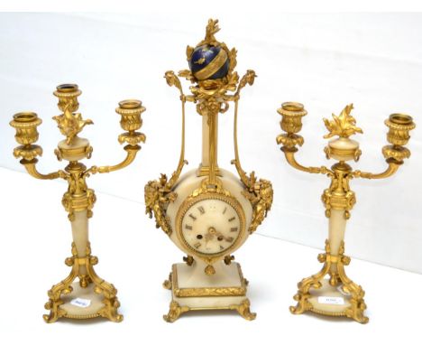 A marble and gilt metal mounted striking mantel clock garniture, circa 1910, surmounted by a sphere and flanked by cockerels 