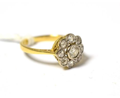 A diamond cluster ring, the old cut and eight cut diamonds in white collet settings to a yellow tapered shoulder plain polish