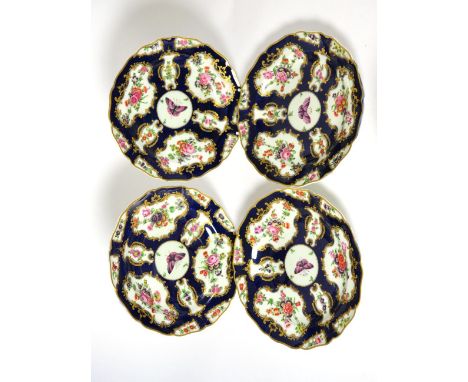 A set of four Worcester style porcelain plates painted with flowers on a blue scale ground, 22.5cm diameter