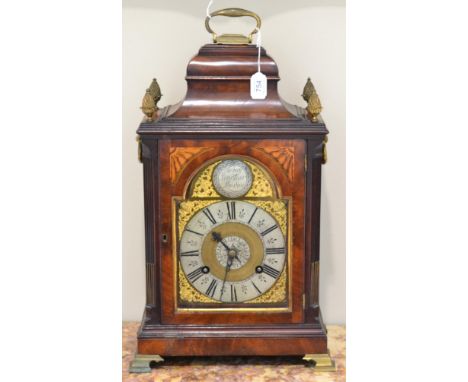 A mahogany striking table clock, inverted bell top with a carrying handle and pineapple finials, side sound frets, 7-inch arc